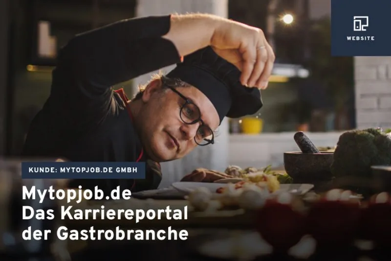 Koch mit erhobenen Armen in der Küche – Teaserbild für das Karriereportal „Mytopjob.de“ der Gastrobranche.
