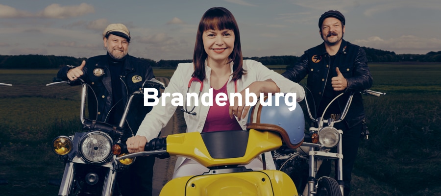 Lächelnde Menschen die auf Motorrädern sitzen in Brandenburg
