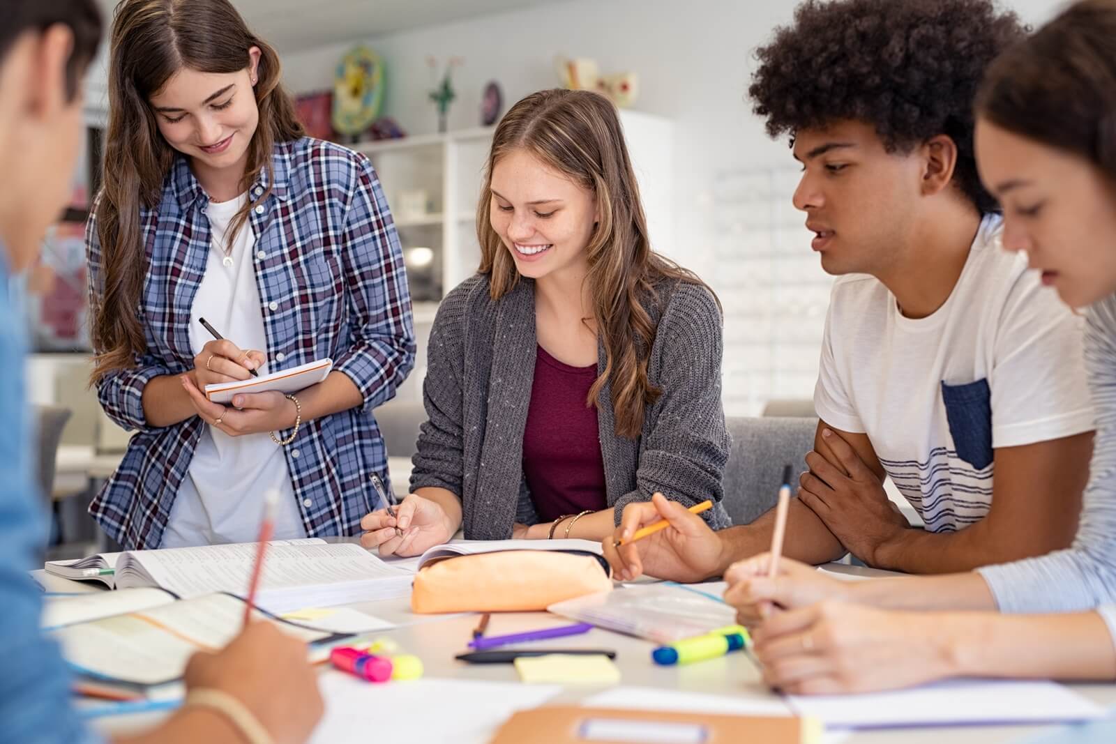 Studenten die an einem Tisch sitzen und sich unterhalten